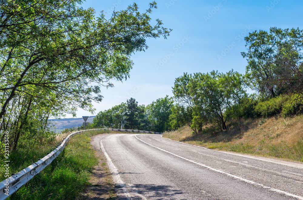 Steep turn of the mountain road. Russia, Republic of Crimea. 11.06.2018: Steep turn of the mountain road in the area of Balaclava Steep turn of the mountain road. Russia, Republic of Crimea. 11.06.2018: Steep turn of the mountain road in the area of Balaclava