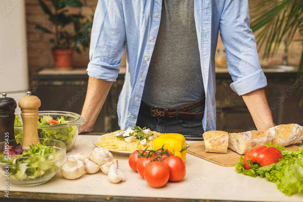 Man preparing delicious and healthy food in the home kitchen on a sunny day. Close-up. Man preparing delicious and healthy food in the home kitchen on a sunny day. Close-up.