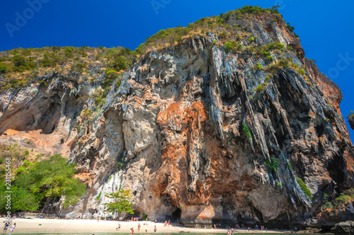 A popular resort and climbing beach, known for its steep, overhanging cliffs like stone icicles hanging over people bathing in the sea. Phra Nang Princess Cave Beach, Krabi, Thailand - Februrary 2014.