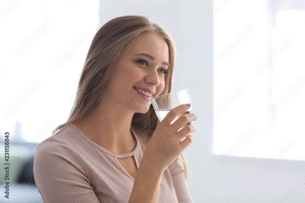 Beautiful young woman drinking water at home Beautiful young woman drinking water at home