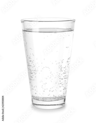 Glass of cold mineral water on white background