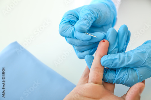 Fotografía Doctor using lancet to get blood sample for test, closeup