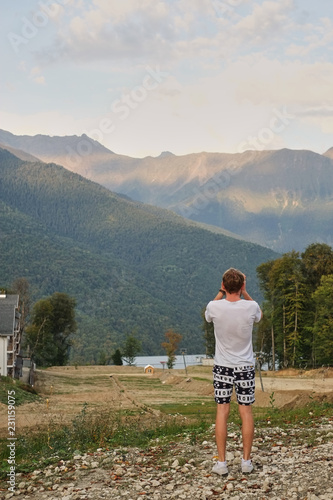 guy in the mountains is photographing a mountain landscape