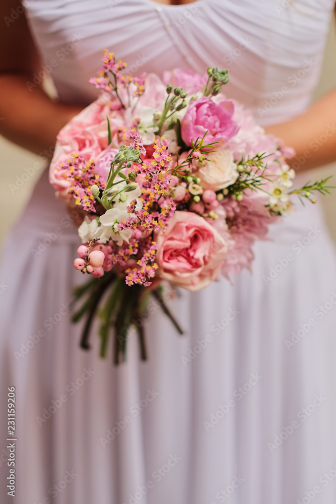 Bride holding a wedding fine-art bouquet in pastel pink colors. closeup. Bride holding a wedding fine-art bouquet in pastel pink colors. closeup.