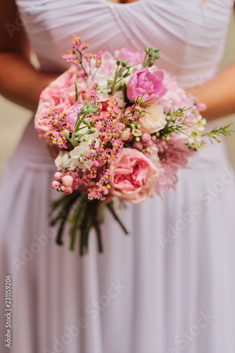 Bride holding a wedding fine-art bouquet in pastel pink colors. closeup.