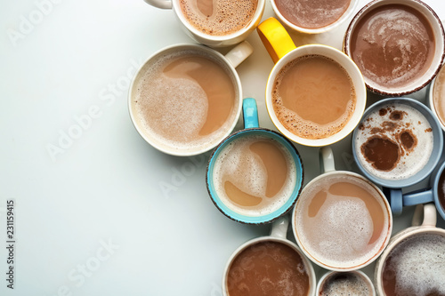 Many cups with tasty aromatic coffee on white background  top view