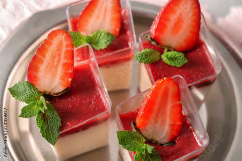 Glasses with tasty strawberry panna cotta on metal tray, closeup