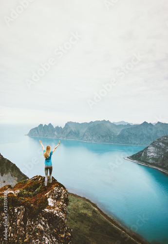 Active girl traveling walking alone on cliff mountain edge above sea adventure healthy lifestyle summer vacations outdoor in Norway photo