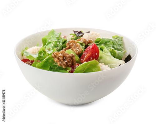 Delicious fresh salad with walnuts in bowl on white background