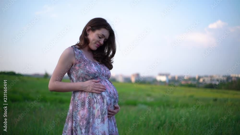 happy pregnant woman touching her belly on nature happy pregnant woman touching her belly on nature