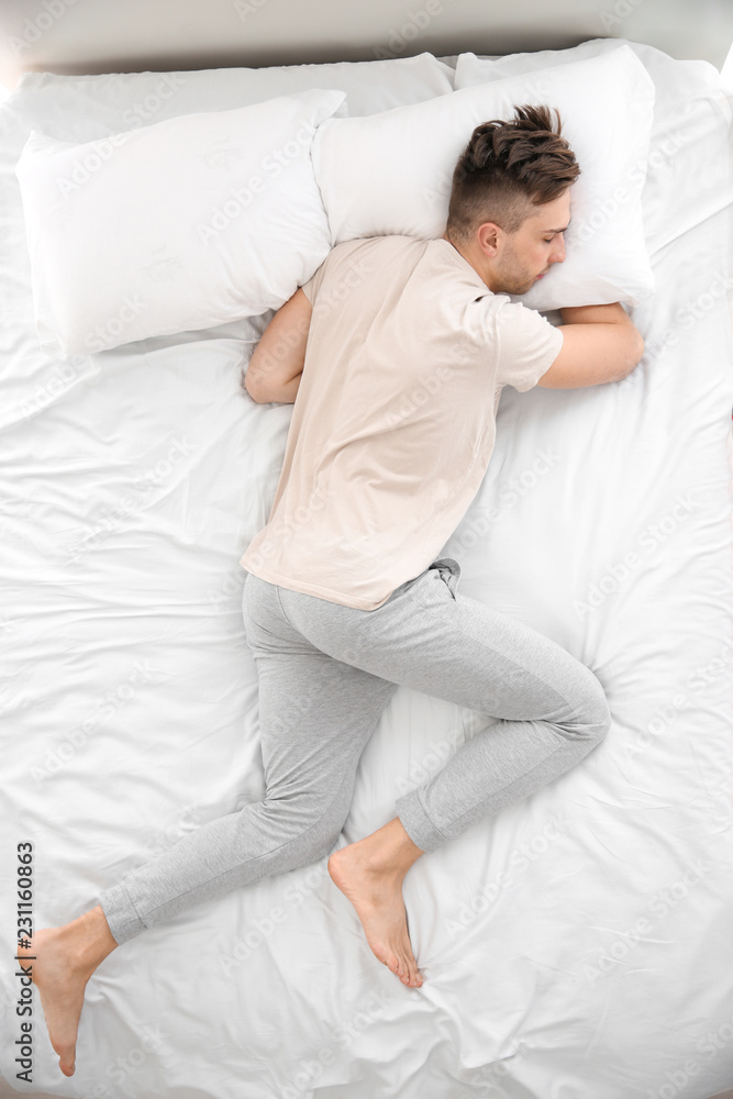 Handsome man sleeping in bed at home Handsome man sleeping in bed at home