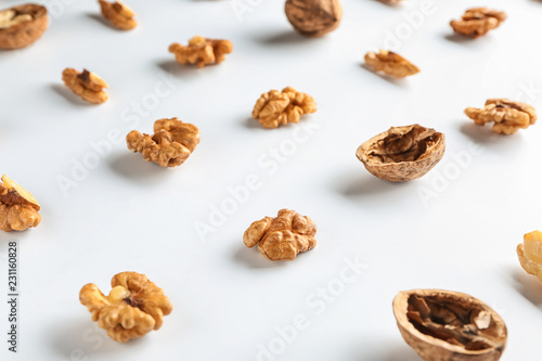 Tasty walnuts with shell on white background
