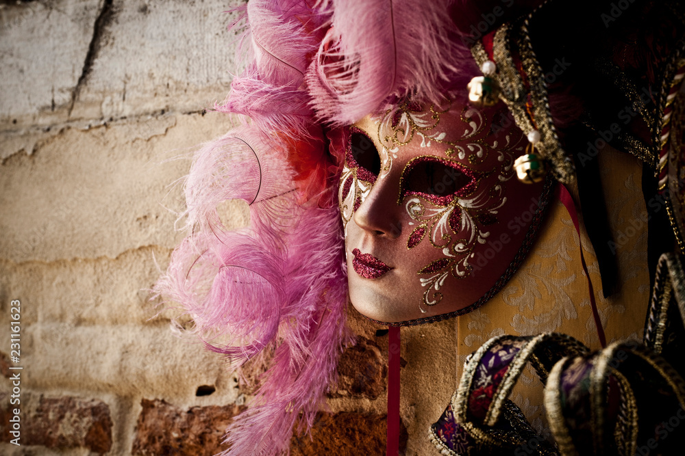 mascara rosa colgada en pared de las calles de venecia