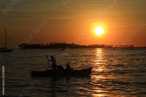 silhouette of a fisherman at sunset © arief