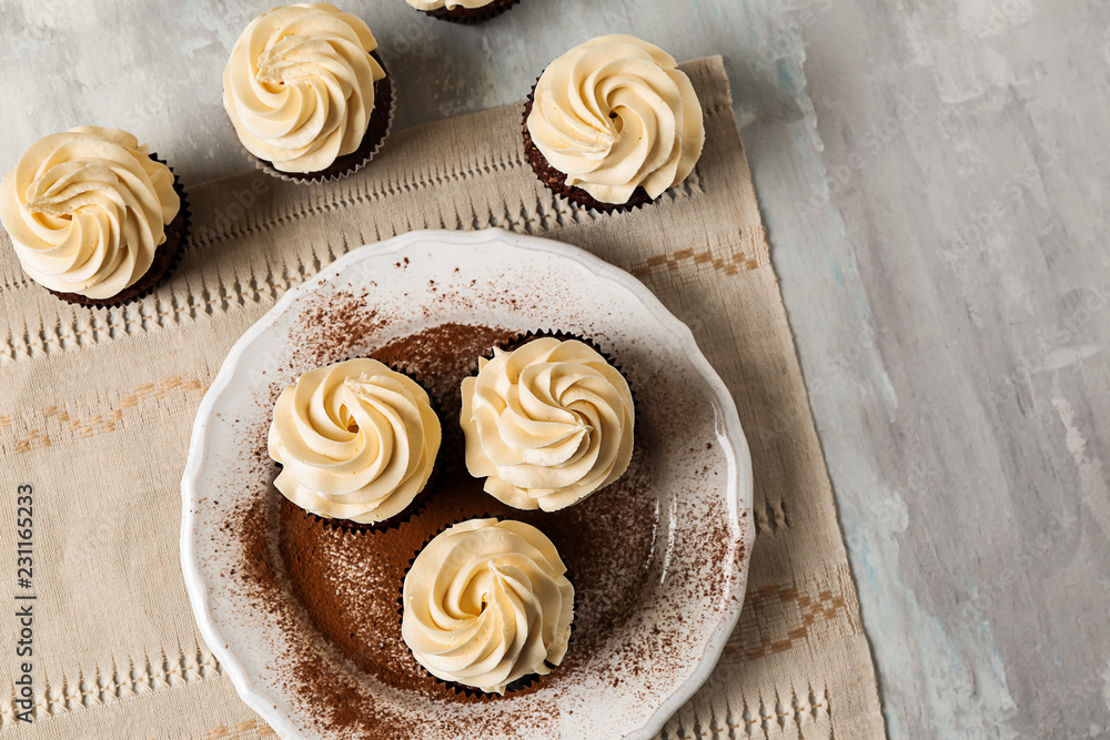 Tasty chocolate cupcakes on grey table Tasty chocolate cupcakes on grey table