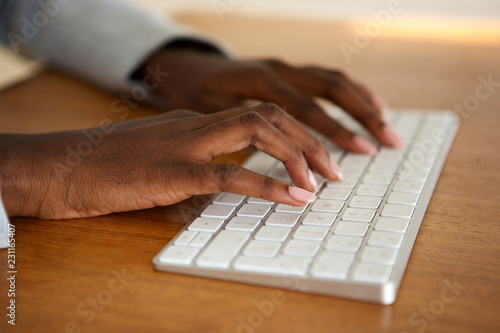 Close up female hands typing on computer keyboard photo