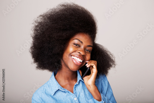 Close up portrait of smiling young black woman talking on cellphone
