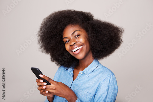 Close up portrait of happy young african american woman smiling with mobile phone