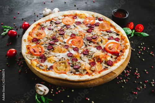Tasty meat pizza with various ingredients on black background