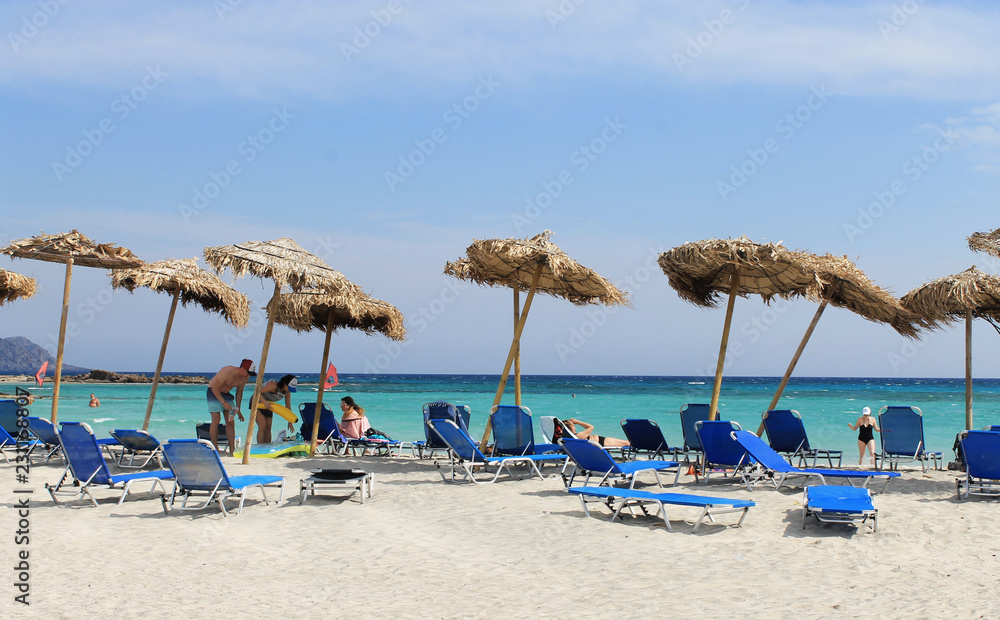 Greek beach on the Islands-Turquoise sea, blue sky, white sand - Umbrellas and blue sun loungers