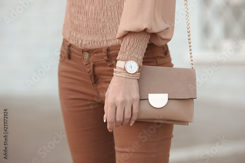 Fashion look autumn woman outfit. Stylish women's beige handbag. Closeup of luxury watch and feminine accessories in pastel colored. Cute beige ladies purse bag. photo