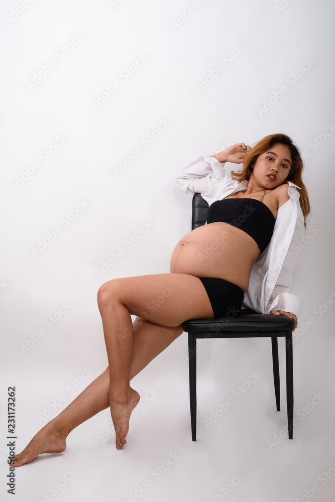 Portrait of beautiful young pregnant Asian woman sitting