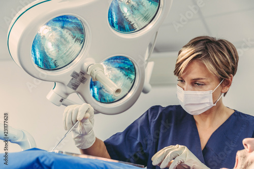 Dental surgeon during surgical procedure on a patient photo