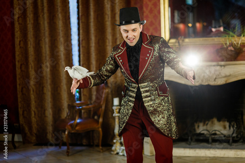 an illusionist is holding a dove in his hands. The magician shows a performance