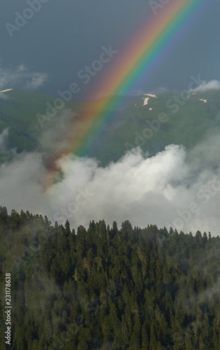 Mountain rainbow. Rainbow after the rain. Summer day in the Western Caucasus.