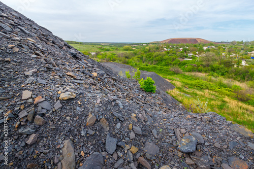 Tableau sur toile The close-up view of the mine waste heap with the other slagheap and the village at the background