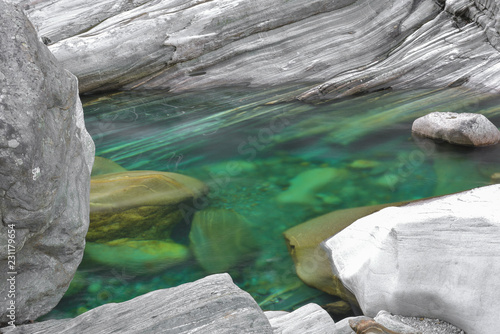 Pozza d'acqua verde immersa tra le rocce stratificate del fiume