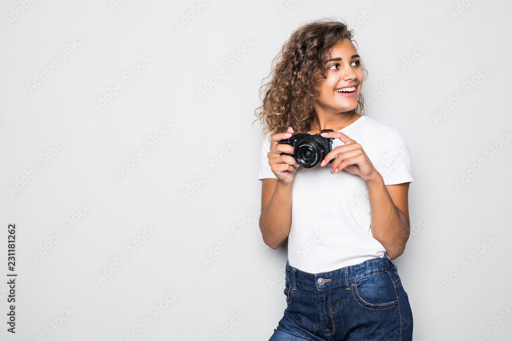 Portrait of beautiful young curly mixed race woman photographer isolated over white background holding camera. Portrait of beautiful young curly mixed race woman photographer isolated over white background holding camera.