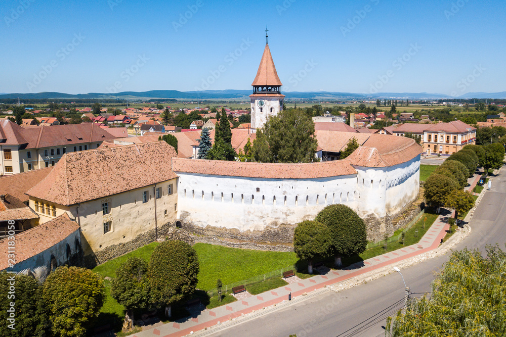 Prejmer Fortified Church, Brasov County, Transylvania, Romania. Medieval fortress with a church, clock tower, high spire, red tiled roof, sthick walls