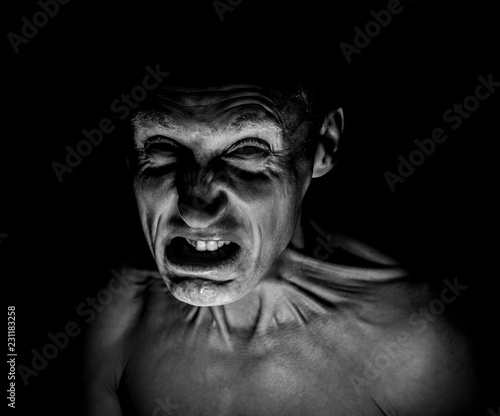 Foto Stylish dark portrait of feared adult caucasian man who wrinkles his face
