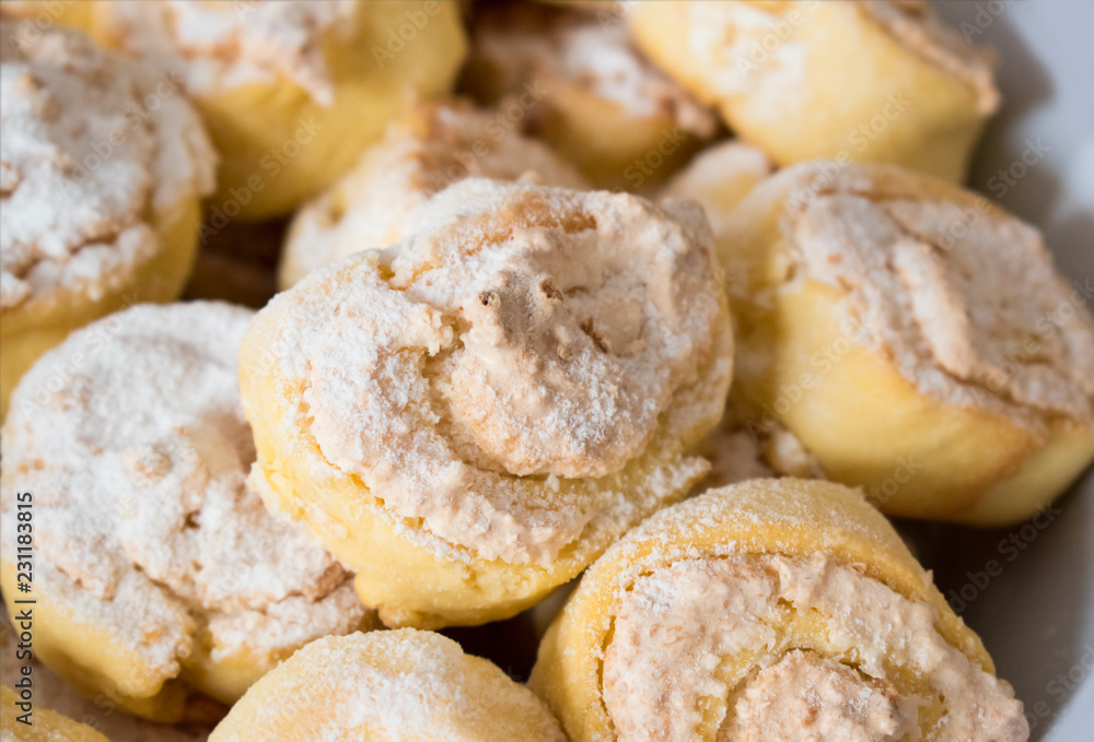 Coconut rolls sprinkled with powdered sugar, close up.