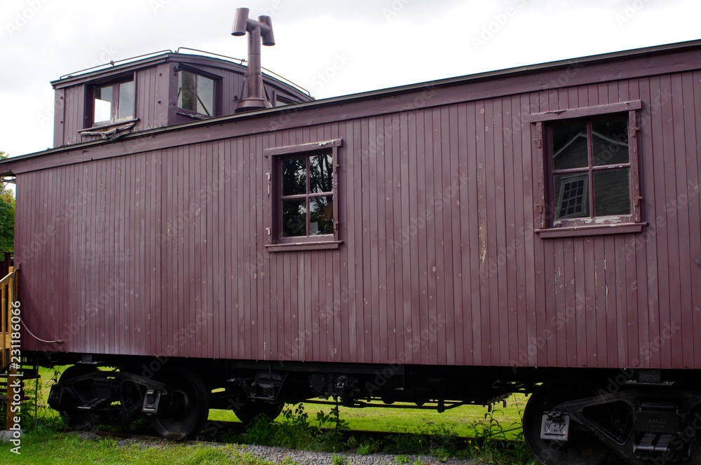 Obraz premium Red antique train caboose on tracks 