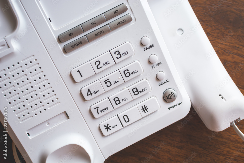 Regular telephone with buttons on the wooden table. Regular telephone with buttons on the wooden table.