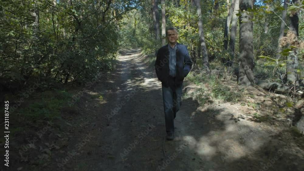 Man Walking through the Forest in Sunny Weather Man Walking through the Forest in Sunny Weather