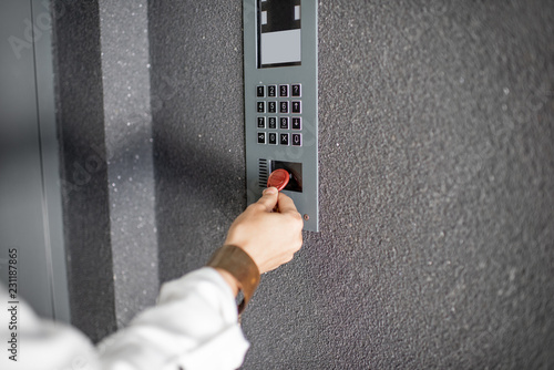 Close-up of intercome keyboard of residential building with keychain opening the door photo