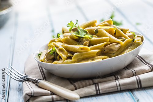 Pasta pene with chicken pieces mushrooms parmesan cheese sauce and herb decor...