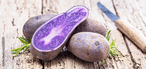 Vitolette noir or purple potato. On a wooden background. photo