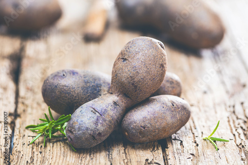 Vitolette noir or purple potato. On a wooden background. photo