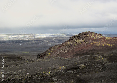 Red volcanic stones, moss and melting glacier on the background, Kverkfjoll, Highlands of Iceland, Europe photo