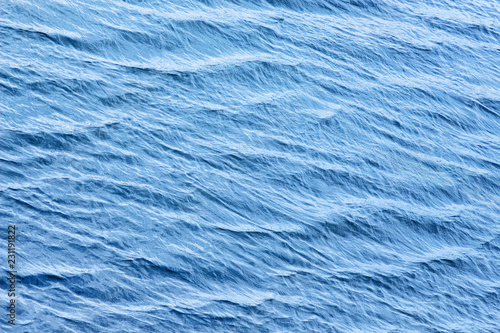 The texture of a blue water surface with waves_