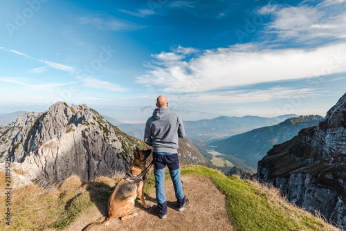 Φωτογραφία Man with dog looking at scenic view from high peak