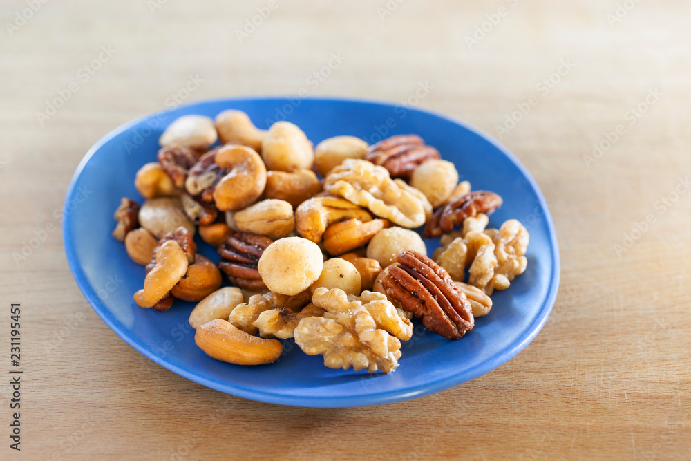 Salted nuts mix on a blue dish