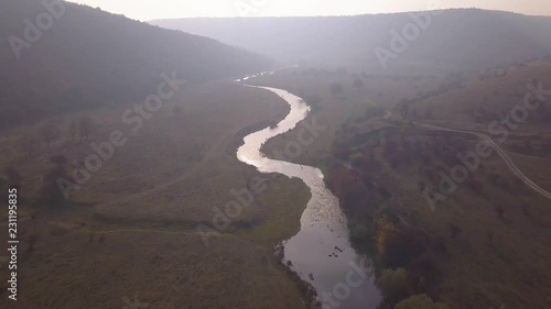 Beautiful sunrisw over river in rural area. Fog over small river. Mountains landscape. photo