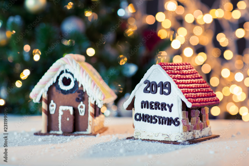 holidays, christmas, baking and sweets concept - close up of beautiful gingerbread houses on table over lights background