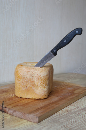 Homemade, fresh, hot, baked bread with a knife