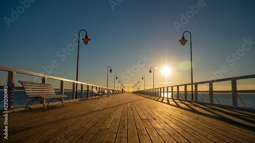 Beautiful and amazing sunrise on the pier at the seaside, Gdynia, Poland. © Kamil